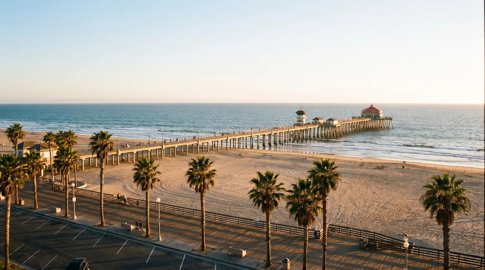 The Huntington Beach pier and a wide sandy beach in late afternoon